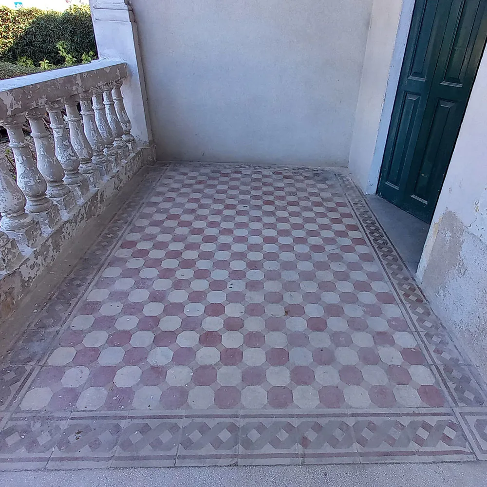 Terrazza della villa prima del restauro: pavimento in cementine decorate opaco e ingrigito, balaustra scrostata
