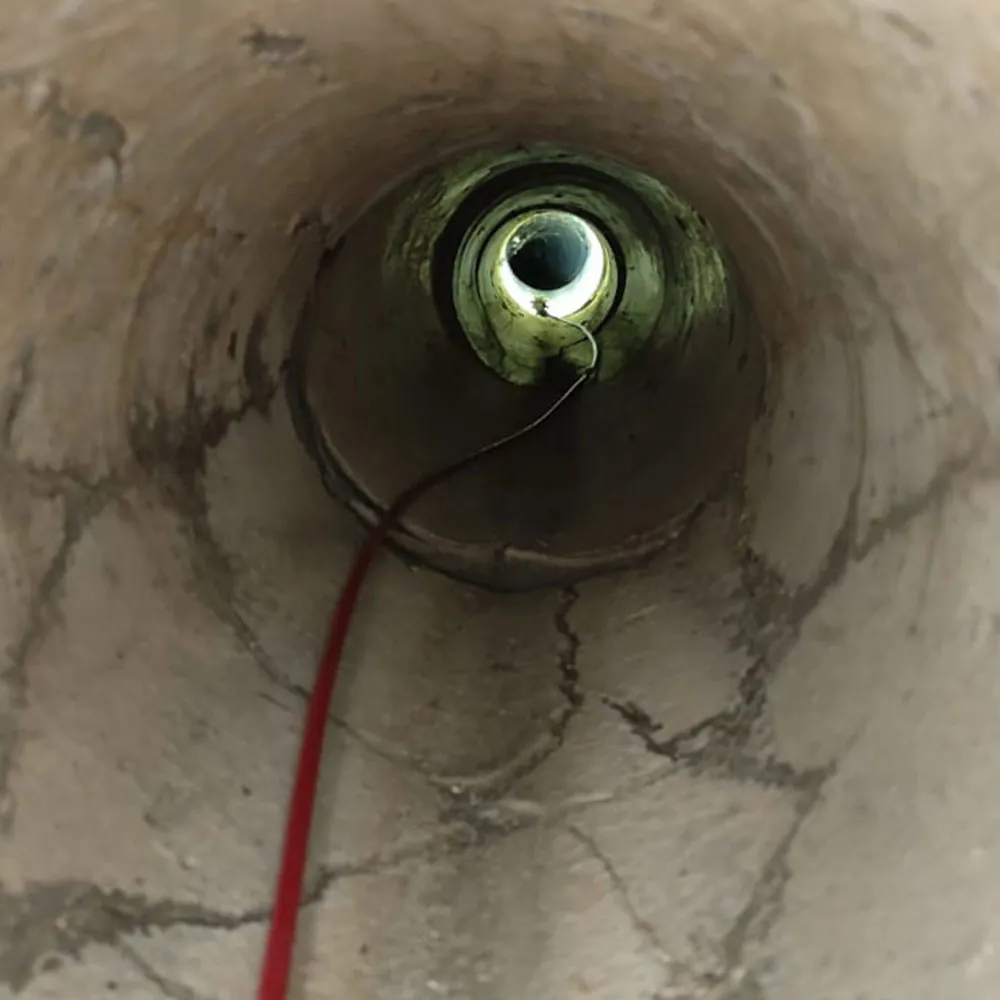 La sonda illumina il tratto successivo del condotto, più stretto, mentre in primo piano sulle pareti sono visibili le fessurazioni